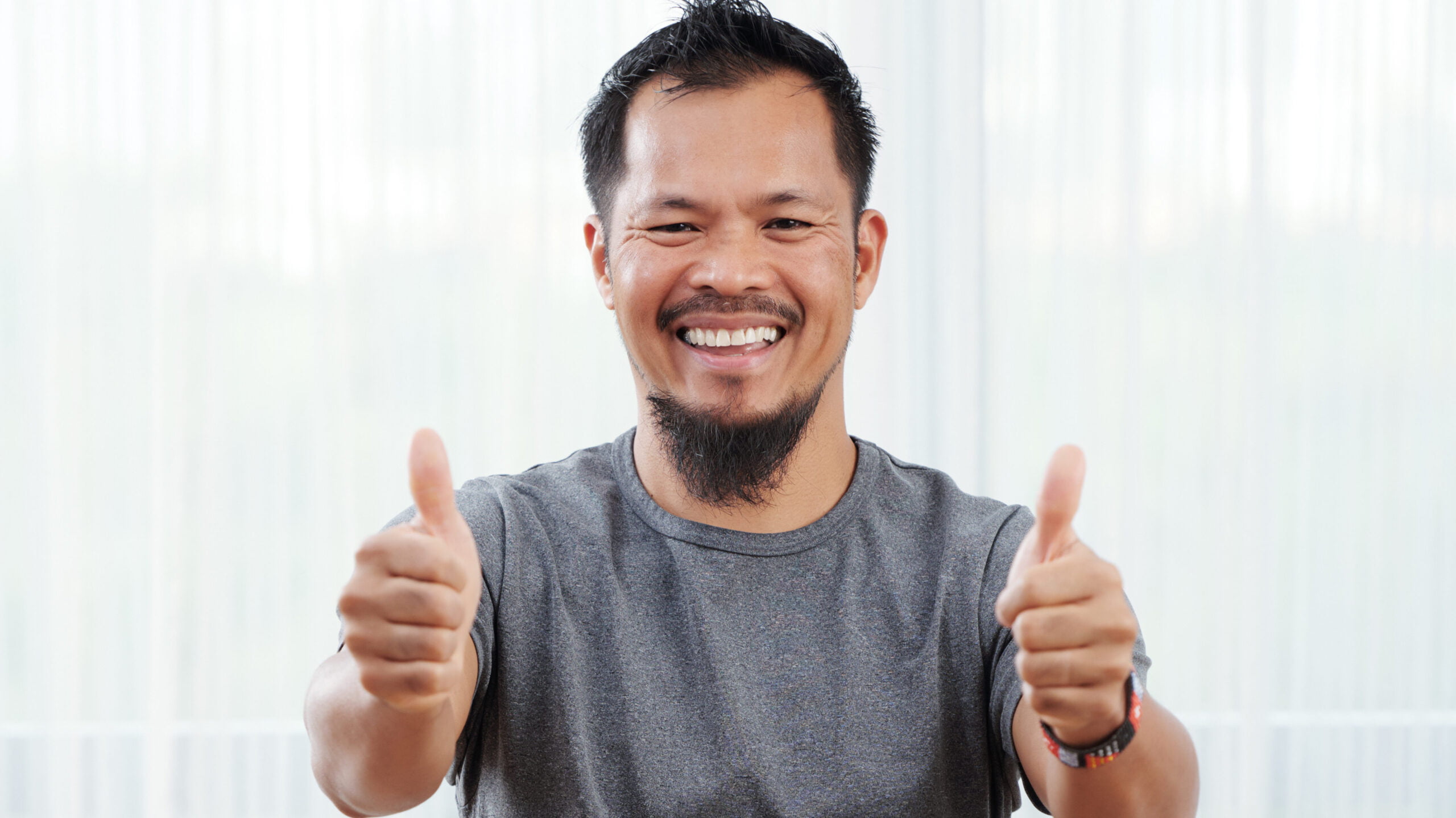 Cheerful-Asian-man-showing-thumbs-up-and-looking-at-camera-mempercepat-kinerja-google-chrome